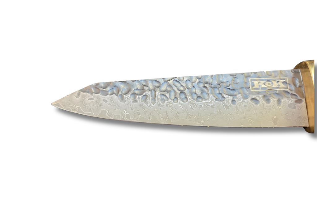 Petty knife hammered blade closeup on a white background