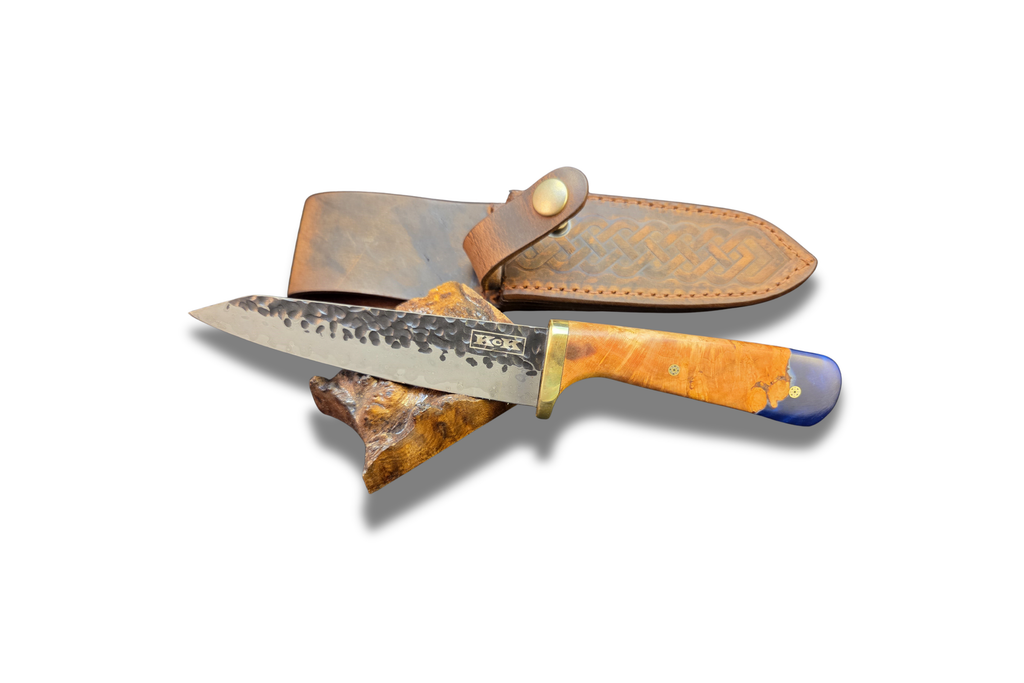Petty knife with a cherry burl and blue resin handle with leather sheath on a white background